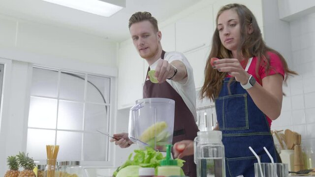 Young couple cooking happy and dancing each other in the kitchen room.