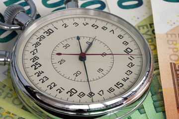 Money macro shot. The stopwatch lies in the center of the banknote layer. Clock. Time is money                                                              
