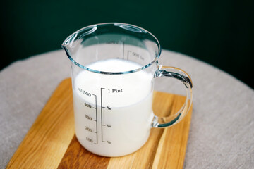 Kefir in a glass dish. Dairy product in a measuring glass top view. Proteins. Fermented milk...