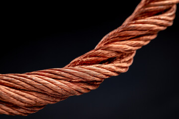 Close-up view of scrap copper wire on black background, selective focus