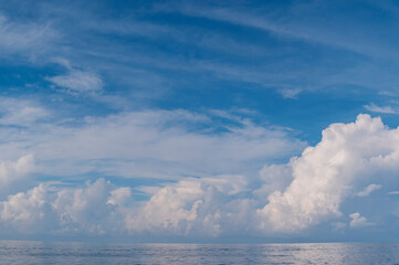 Blue sky and white fluffy clouds with reflect on sea background and pattern