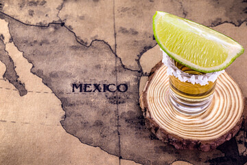 glass of tequila with map of mexico in the background, image to celebrate tequila day