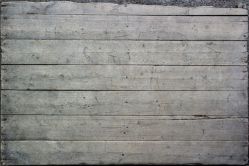 Texture of old rough unpainted planks on the old wooden pallet surface with nails