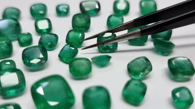 Emerald Stones moving with Tweezer by Gemologist 