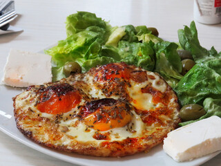 Breakfast on the table, eggs, green salad, olives and cheese