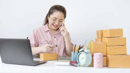 Young woman selling products online was talking on the phone to receive an order from a customer who called and wrote down the list in a notebook, New kind of business for young, Sell online.