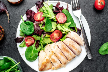 Chicken fillet with salad and spinach. Healthy food on stone background