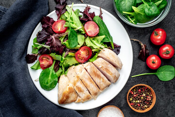 Chicken fillet with salad and spinach. Healthy food on stone background