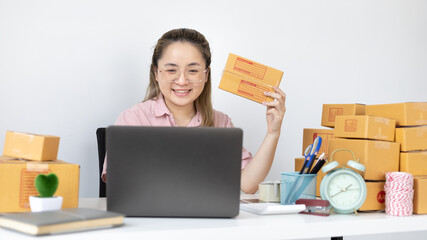 Young woman uses a laptop to chat with customers who come to order product, New young businesses that can work from home and deliver their goods by post, Sell online or Online sell.