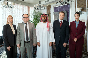 A group of people standing in boardroom while posing for a photo