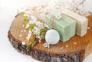 Soap banner. Aromatic Natural Soap and bath bomb with sakura flowers on wooden background, close up