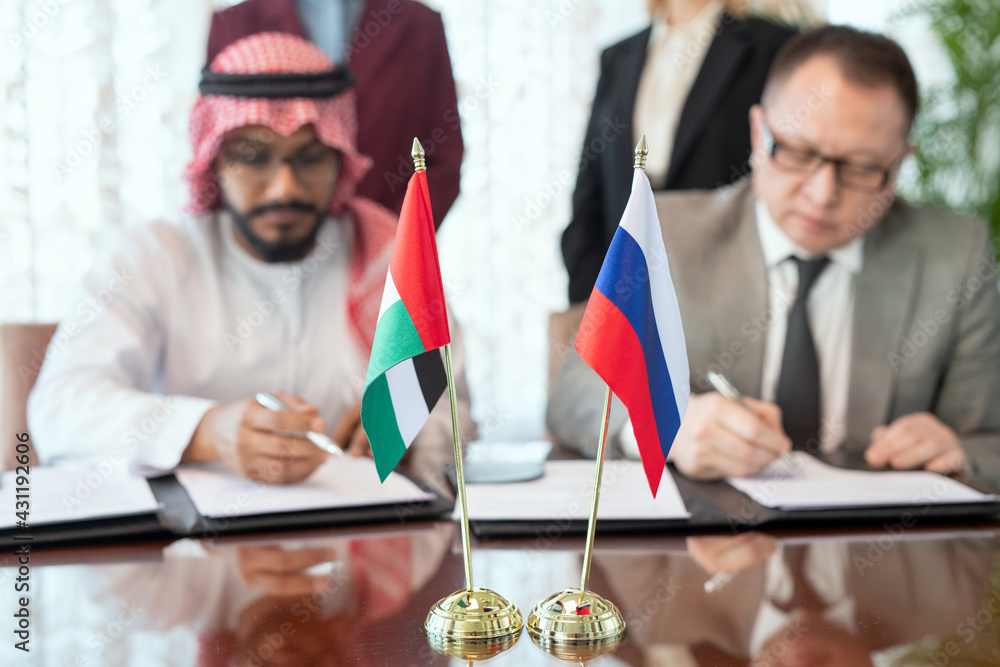 Aufkleber a group of men sitting at a table with flags and signing agreement or contract