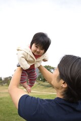 Japanese newborn baby and father relaxing in the park