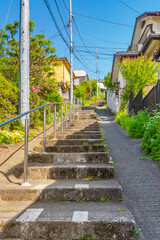 日本の住宅地。高低差がある道の石段。Residential area in Japan. A stone staircase on a road with a height difference.