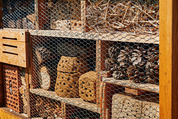 View to an insect hotel made of different materials to offer a retreat for many species. The focus lies on the right side of the photo.