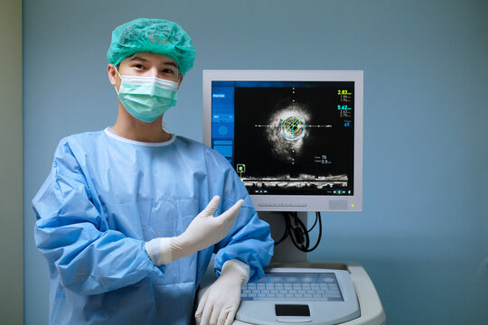 Doctor wears sterile uniform and uses Intravascular ultrasound imaging (IVUS) machine at cardiac catheterization laboratory room