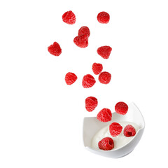 Fresh raspberries falling into bowl  with yogurt isolated on white