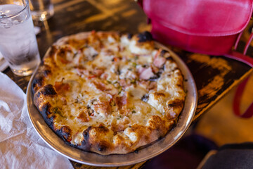 Tasty cheese pizza and a glass of water on vintage-looking table