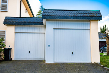 Obraz na płótnie Canvas wide garage door and concrete driveway in front