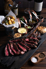 tomahawk steak on a wooden cutting board placed on a wooden table