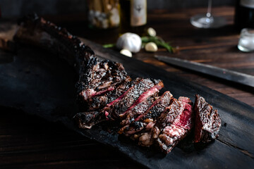 tomahawk steak on a wooden cutting board placed on a wooden table
