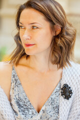 Portrait of a beautiful middle-aged woman in knitted clothes with a black brooch