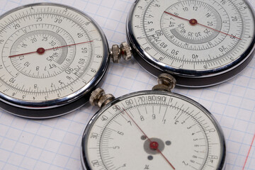 Logarithmic ruler closeup and colorful pencils on a white background. Vintage antique round slide ruler Calculator, felt-tip pens, office, calculating device. Maths. Mathematical. Measuring instrument