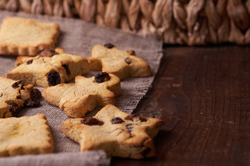 Healthy homemade gluten-free, lactose-free cookies of various shapes without sugar with raisins and chocolate on a dark brown wooden background