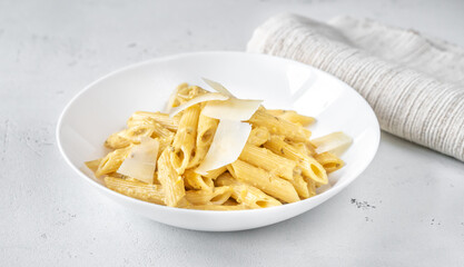 Portion of penne pasta with yellow pesto sauce