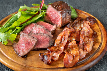 Beef steak with fried bacon