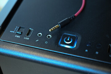 a red cable with a mini jack connector lies on the computer's system unit near the headphone jack