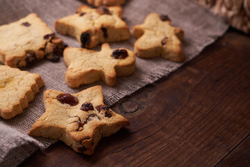 Healthy homemade gluten-free, lactose-free cookies of various shapes without sugar with raisins and chocolate on a dark brown wooden background