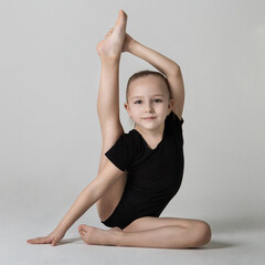 little gymnast demonstrates flexibility and balance in a gymnastic pose