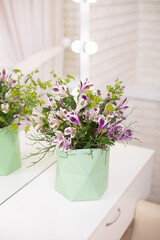 Fototapeta premium Beautiful flower bouquet in vase on table in beauty salon, mirror reflection 