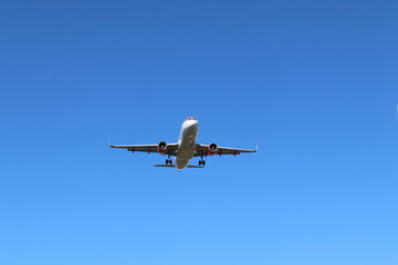 Fototapeta na wymiar Avión aterrizando con el cielo azul y despejado