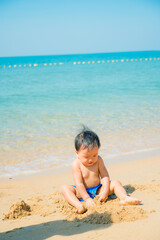 1 year 3 months old baby boy playing sand on the beach,Holidays with baby summer concept.