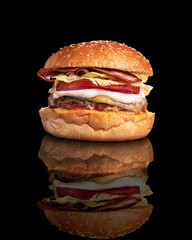 burger with bacon tomato and sauce on a black background