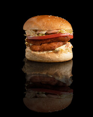 chicken burger with jalapeños sauce on a black background