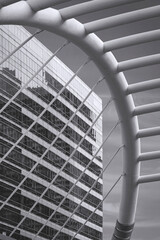 Low angle view of high-rise glass building inside of curve railing structure of Chong Nonsi skywalk bridge at Bangkok, Thailand in black and white style