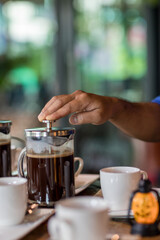 Hand preparing coffee in French Press Coffee Maker. Morning concept. coffee siphon. Spent coffee break at the organic cafe and prepare Chocolate or tea in French press.