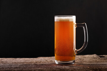 Pouring a glass of brown beer on a rough wooden table