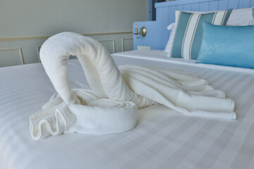 Fototapeta na wymiar White swan blanket origami decoration on the bed.