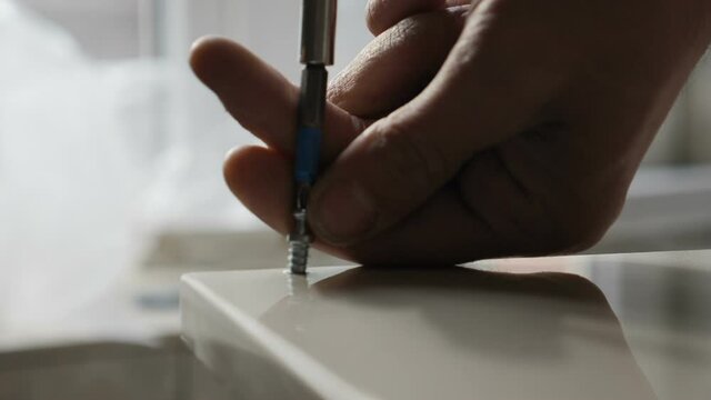 Furniture assembly. House improving and repairing. handyman at work. Locksmith screwing. Tighten screw with screw driver. Slow motion. Drilling nail into table surface. Construction worker. Full hd