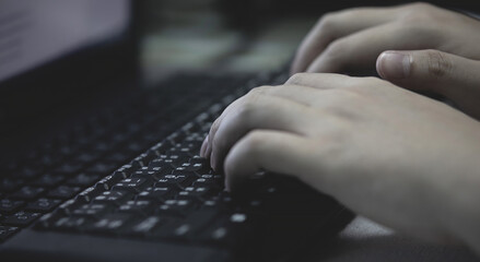 Working at home with laptop man writing a blog. male hands on the keyboard.