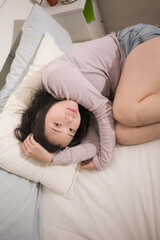 young Asian woman depressed - young beautiful and sad  Japanese girl on bed with pillow feeling unhappy and broken heart suffering depression problem at home bedroom