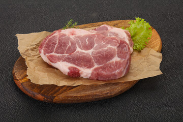 Raw pork steak over wooden board