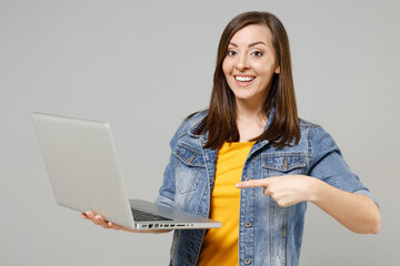 Young fun surprised excited caucasian woman 20s in casual trendy denim jacket yellow t-shirt point...