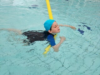 boy in the pool learns to swim