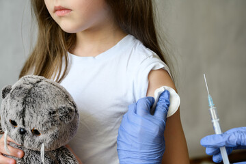 Kid and COVID-19 vaccination, cute little girl during corona virus vaccine injection