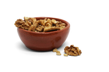 Glazed ceramic bowl with walnuts and pine nuts. Isolated over white background.